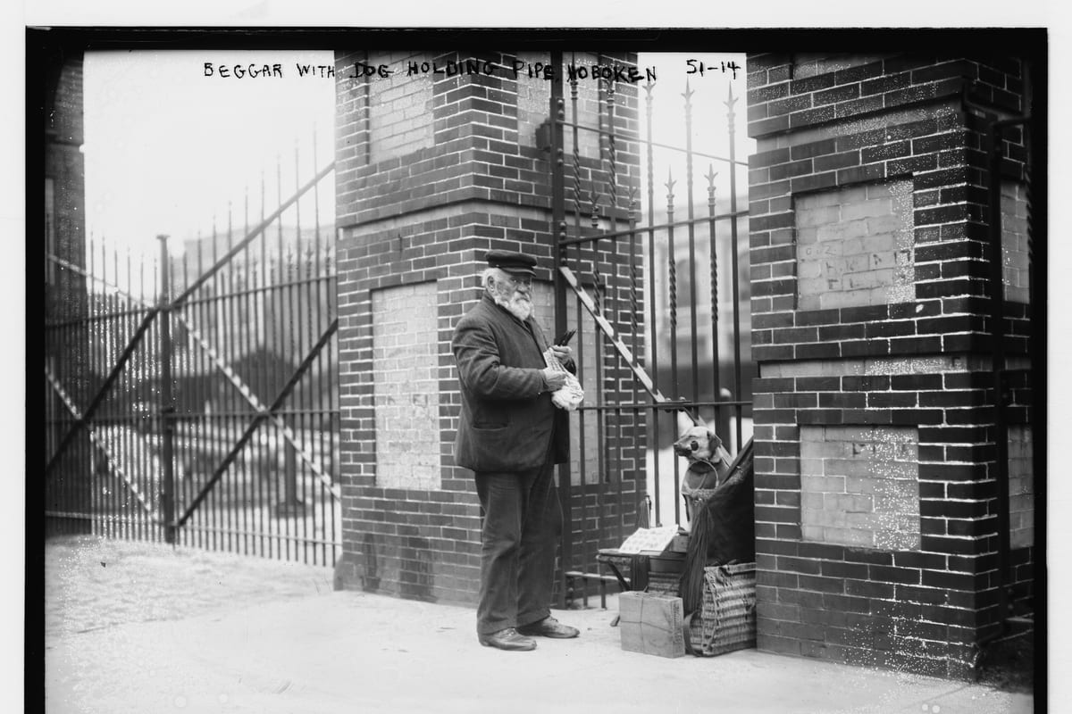 Hoboken, NJ — Beggar with dog, holding pipe Hoboken, (New Jersey) LCCN2014680261